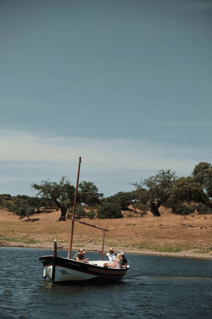 Barco no lago do Alqueva com azinheiras na margem